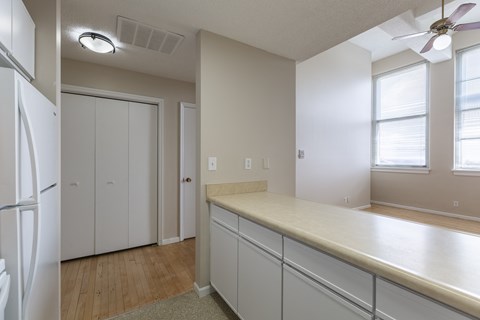 A kitchen with white cabinets and a refrigerator.
