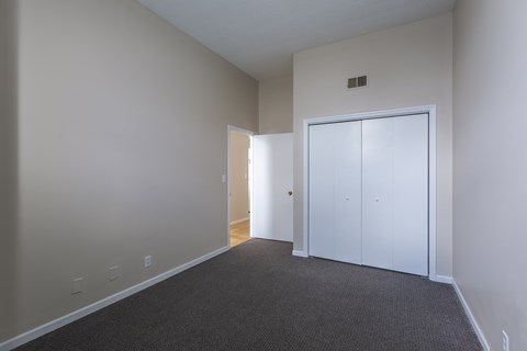 A room with a carpeted floor and a white door.