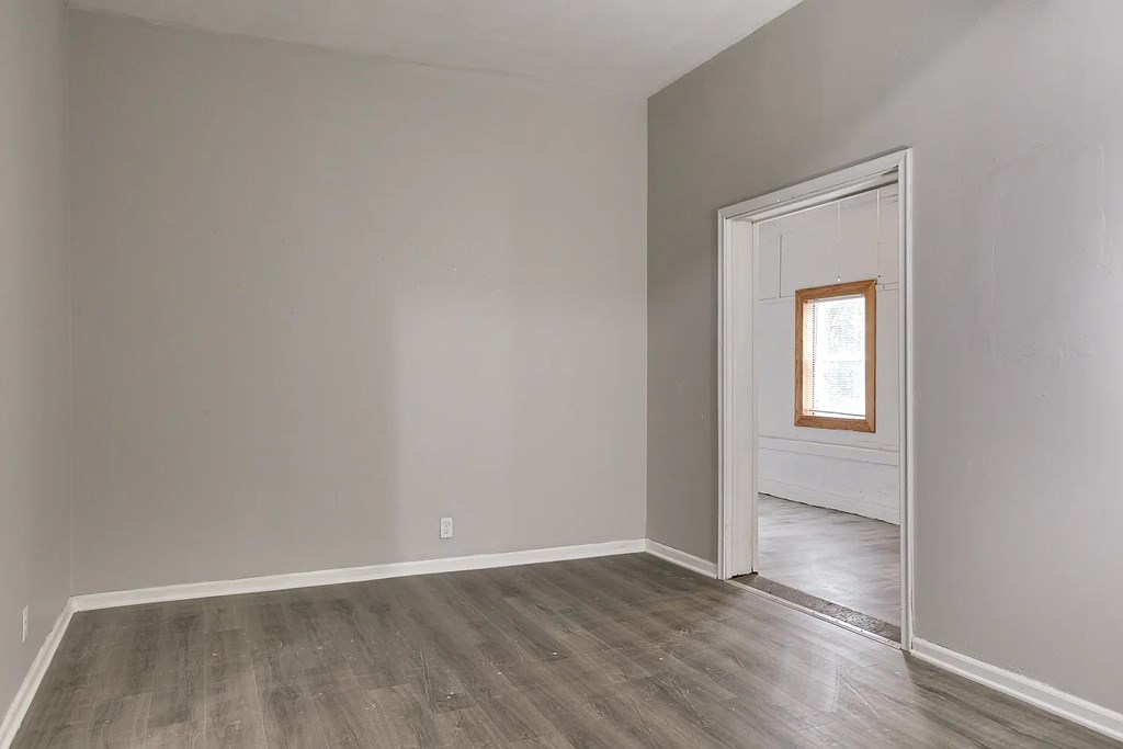 A room with a wooden floor and a white door.