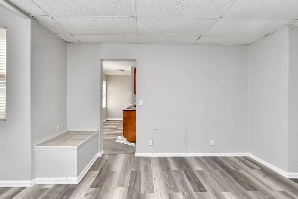 A room with a wooden floor and white walls.
