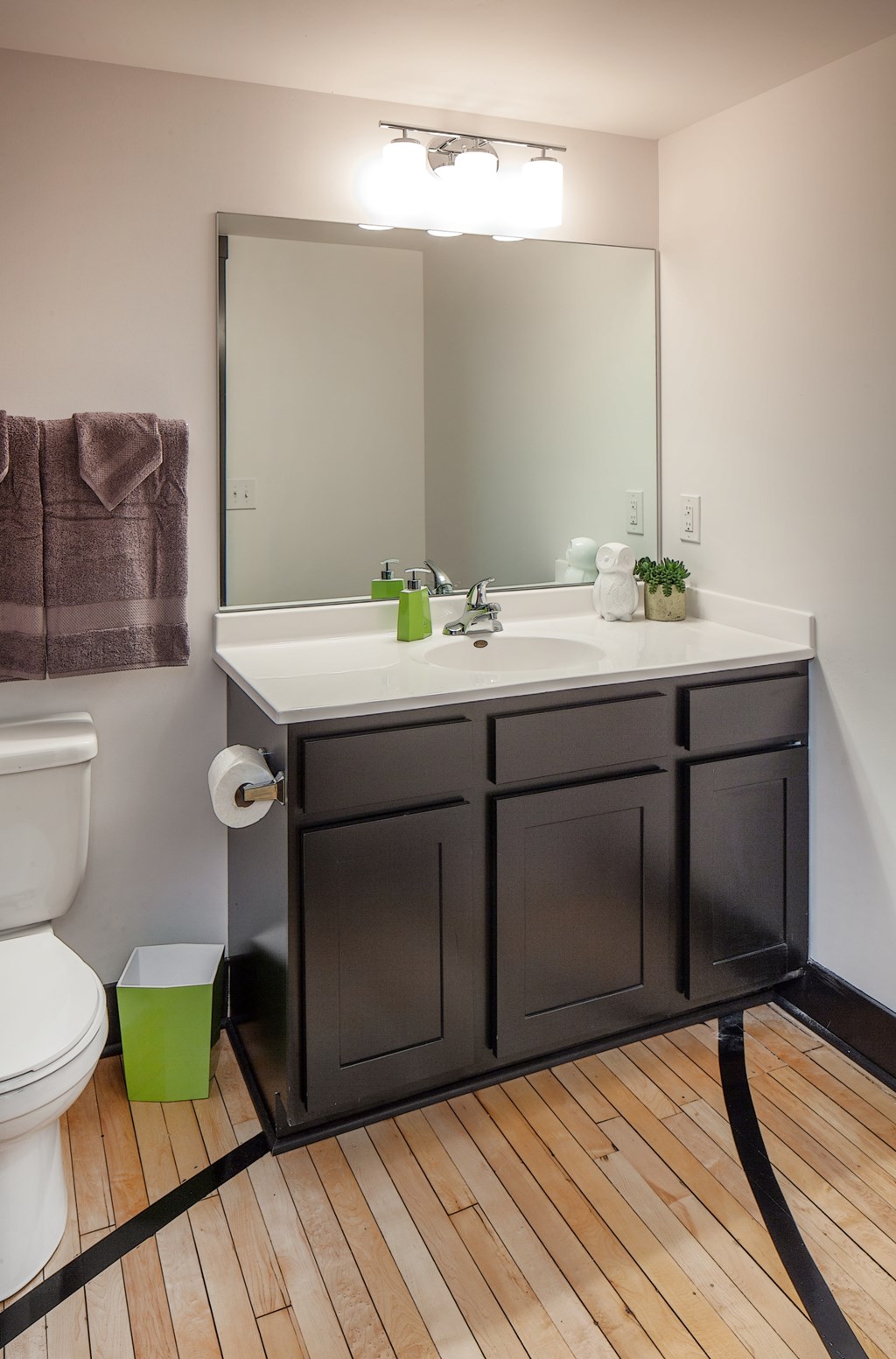 A bathroom with a white sink and a brown cabinet.