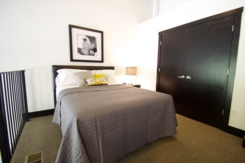A bedroom with a bed, a picture frame, and a wardrobe.
