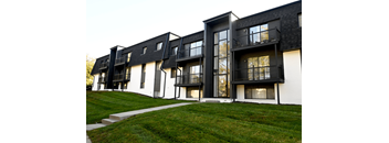 Exterior view of a modern apartment building with balconies and landscaped lawn at Cielo 120