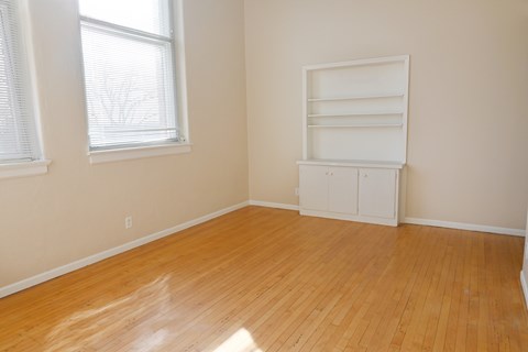 A room with a wooden floor and a white cabinet.