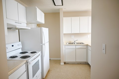 A kitchen with white appliances and cabinets.