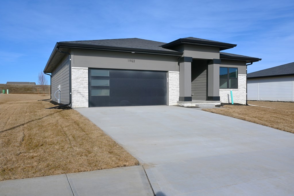 A modern house with a grey and white exterior and a black roof.