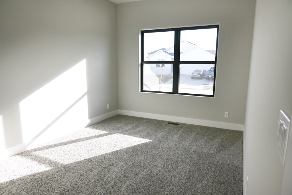 A room with a large window and carpeted floor.