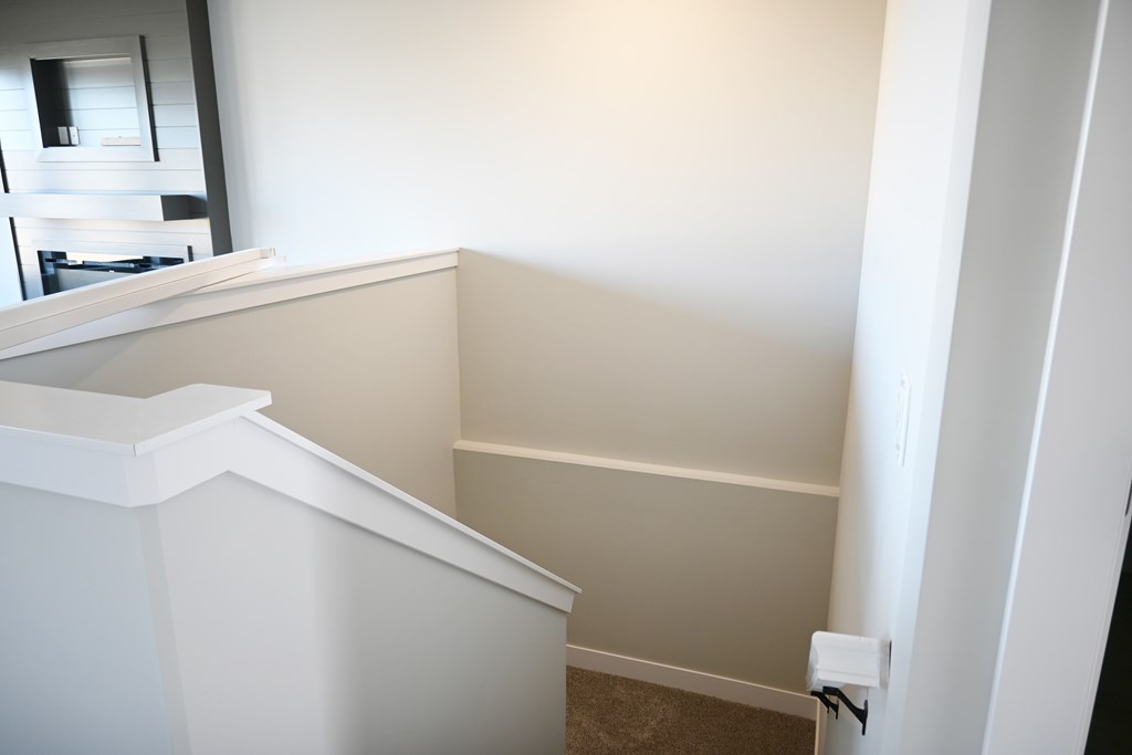 A white staircase with a carpeted floor.