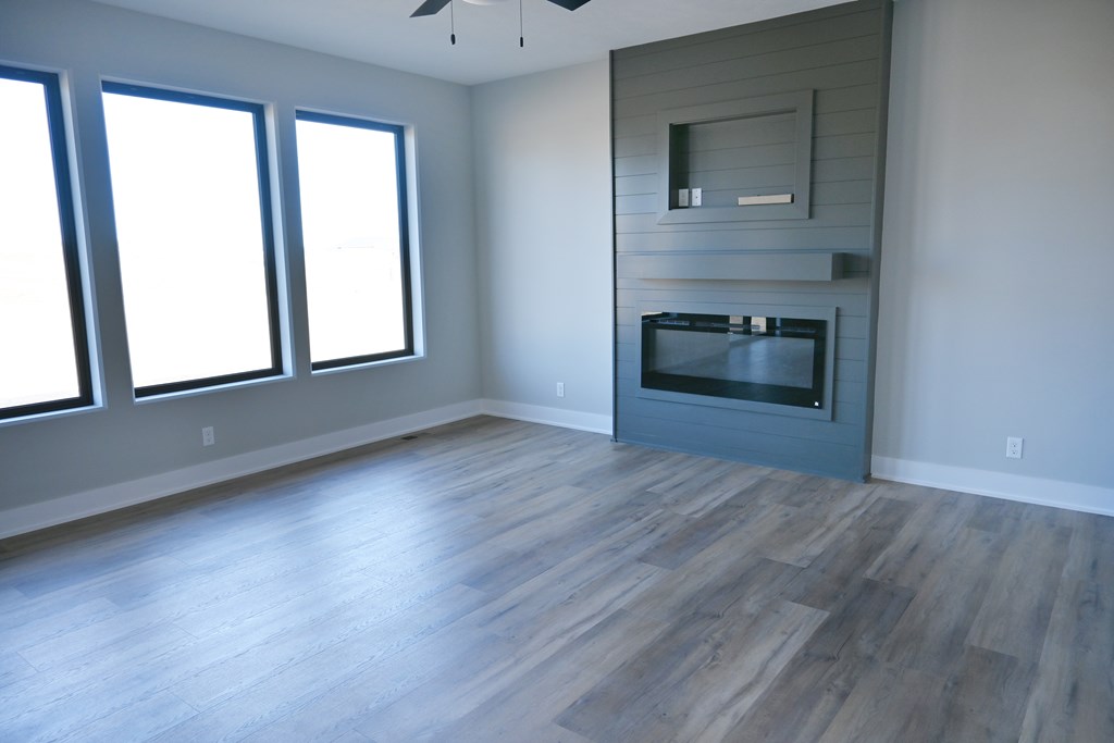 A modern living room with a fireplace and wood flooring.