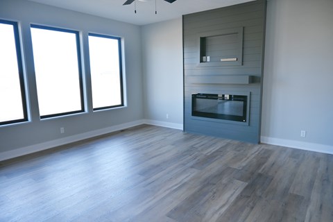 A modern living room with a fireplace and wood flooring.