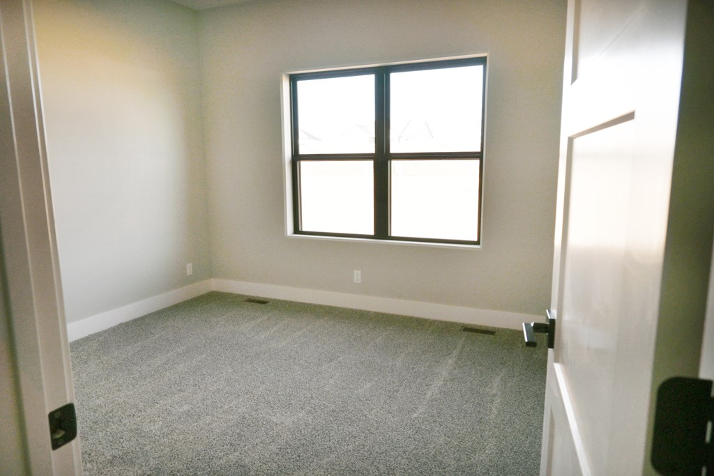 A room with a carpeted floor and a window.