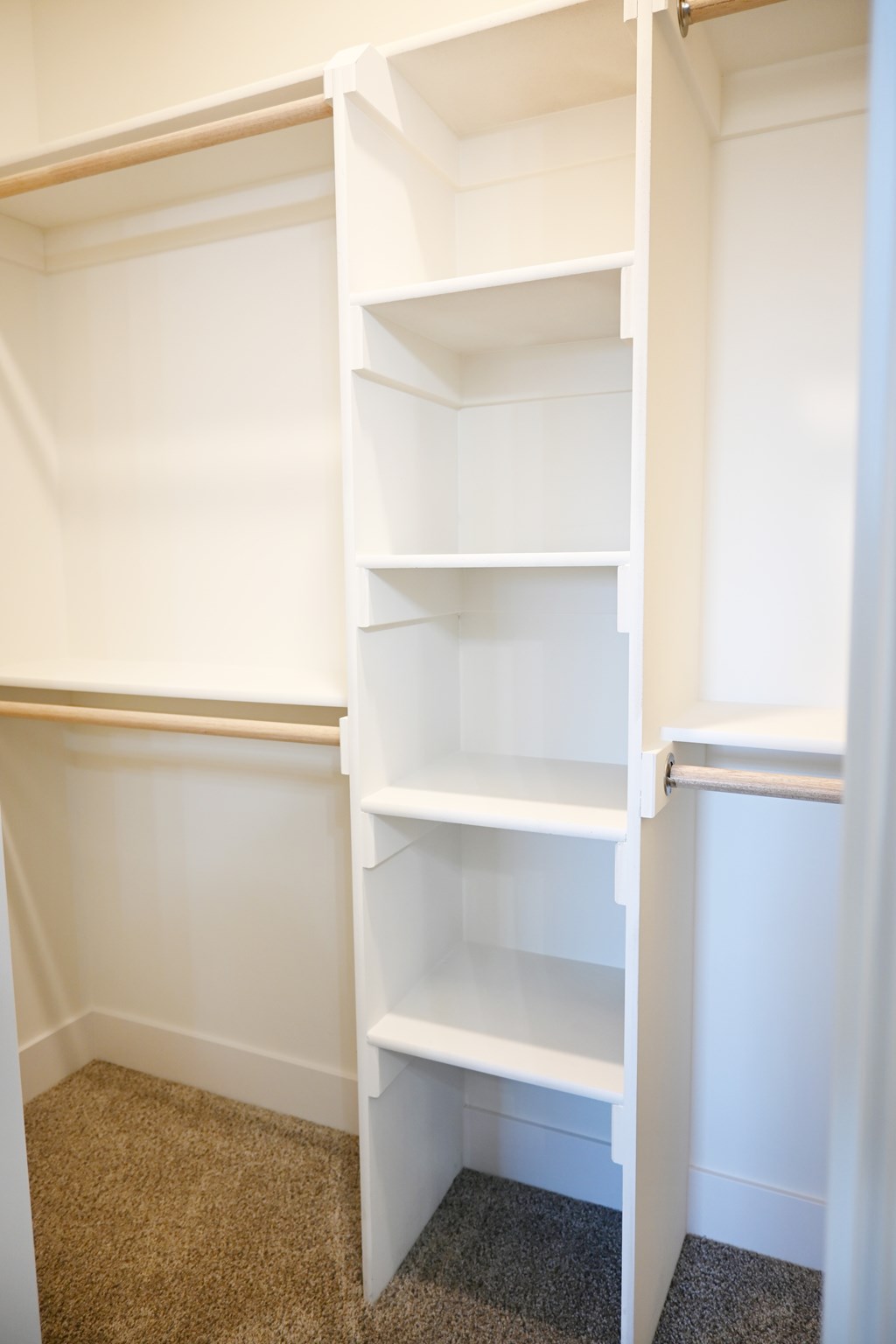 A white shelving unit in a corner of a room.