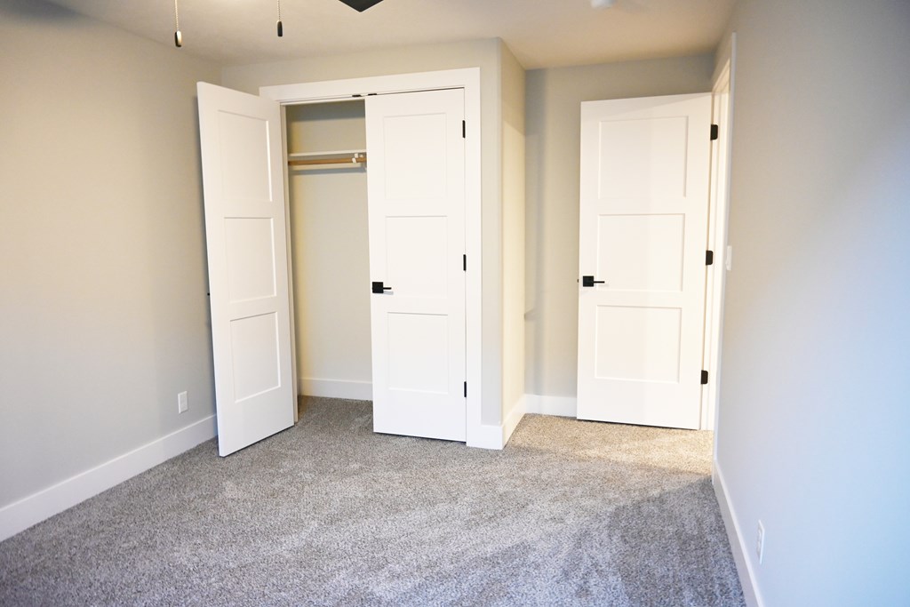 A room with two white doors and a carpeted floor.