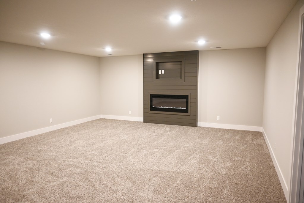 A room with a fireplace and carpeted floor.