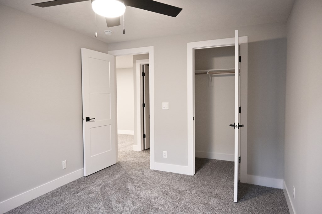 A room with a ceiling fan and two doors.