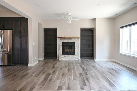 A modern living room with a fireplace and wood flooring.
