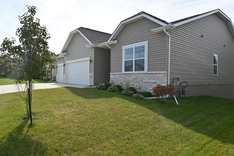 A house with a grey roof and a white garage door.