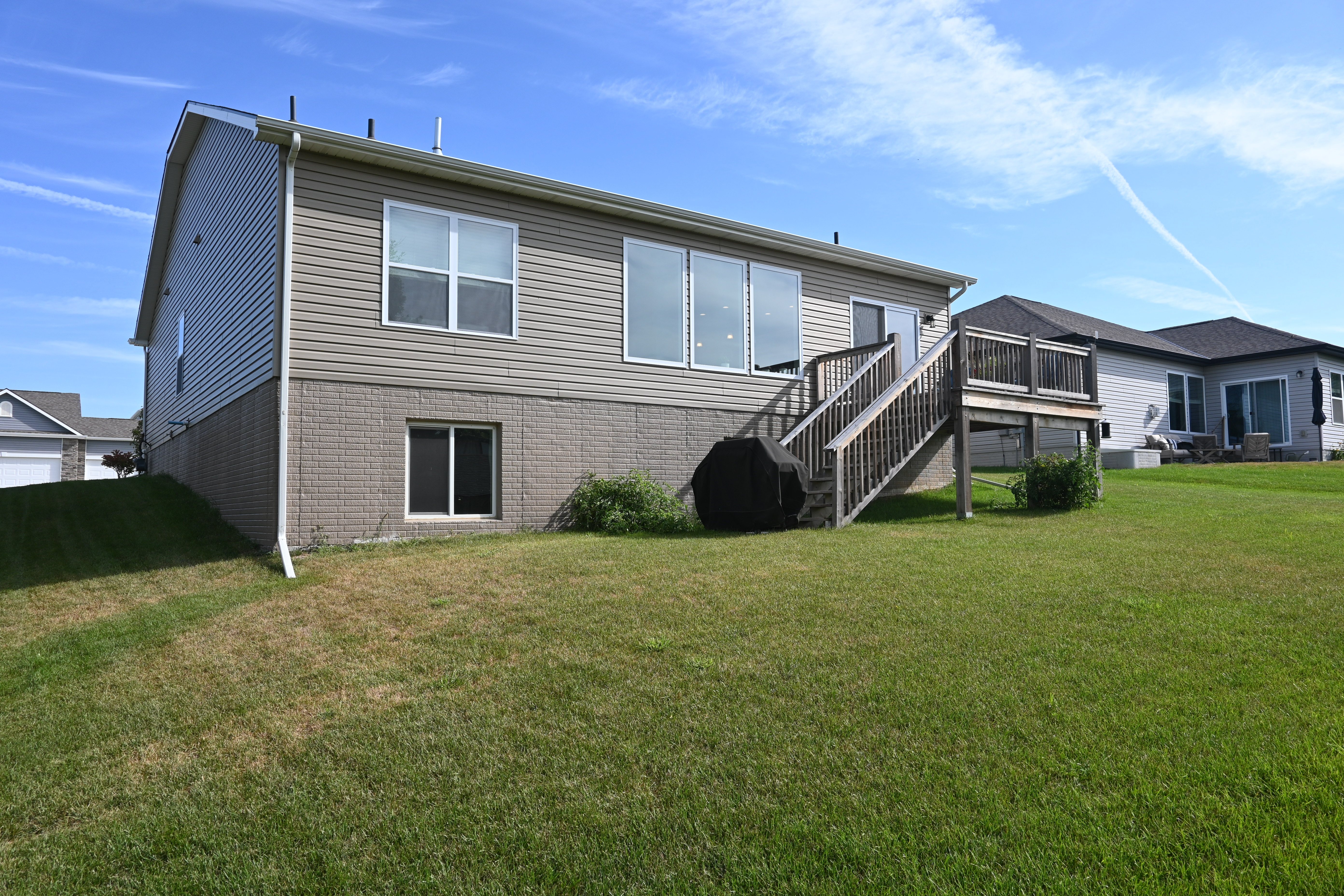 A house with a grey siding and a black staircase.