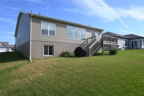 A house with a grey siding and a black staircase.