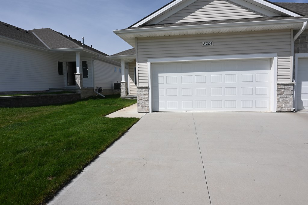 A white house with a garage door that is open.