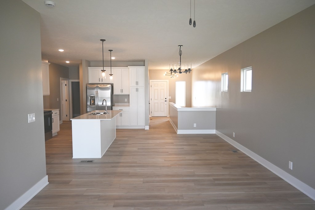 A modern kitchen with a white island and wooden floors.