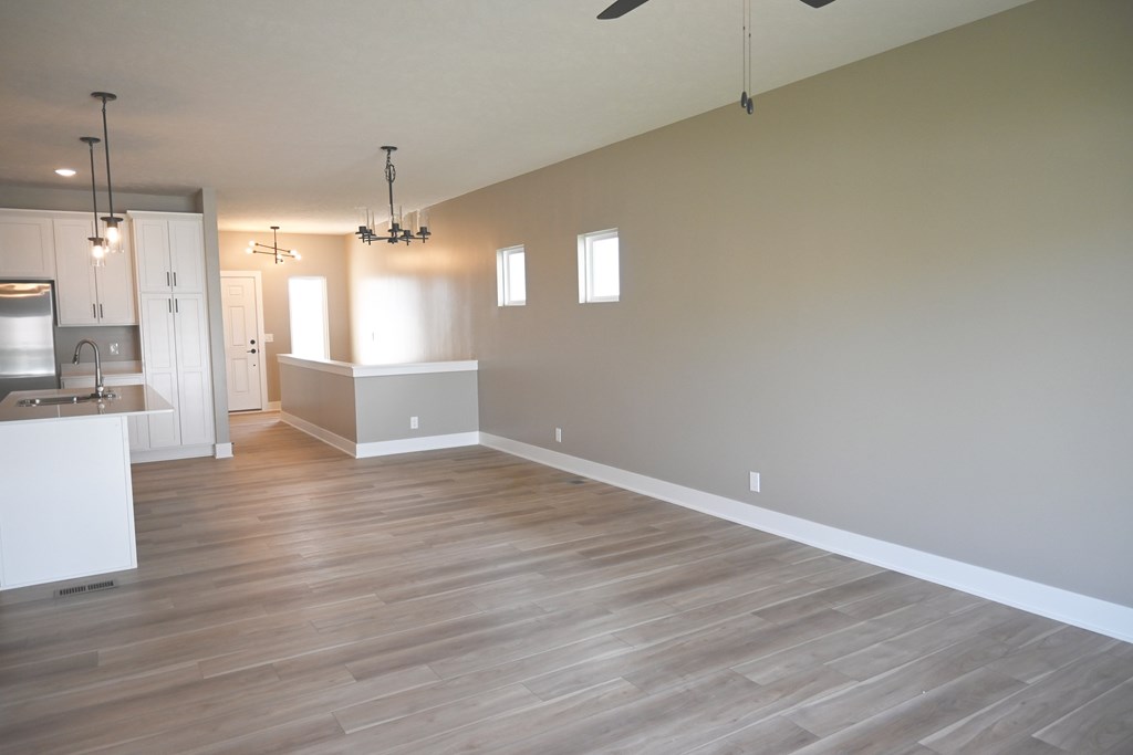A large empty room with wooden floors and white walls.