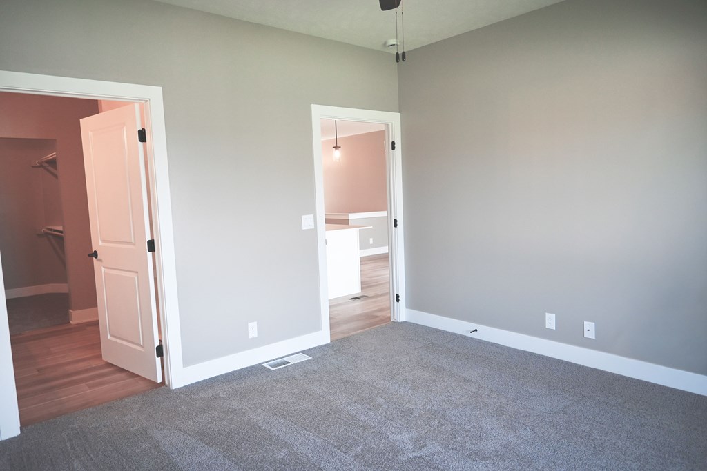 A room with a carpeted floor and two open doors.