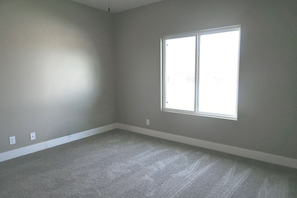 A room with a carpeted floor and a window.