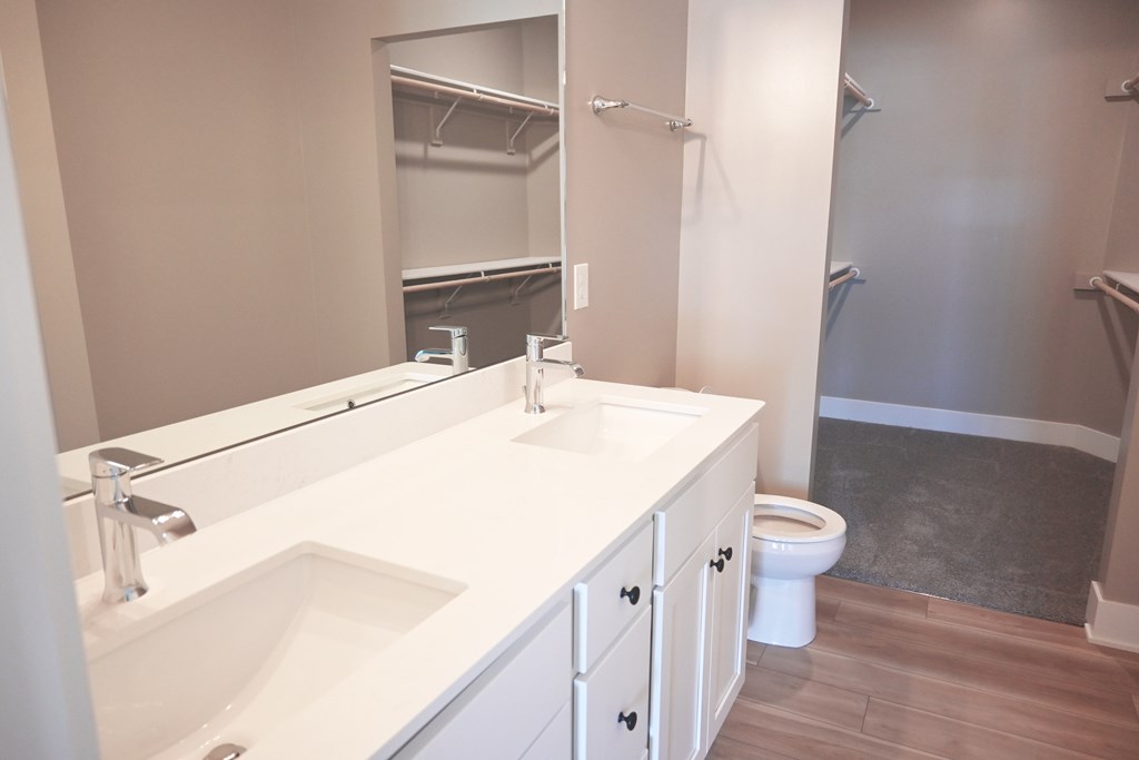 A white bathroom with a sink, toilet, and mirror.