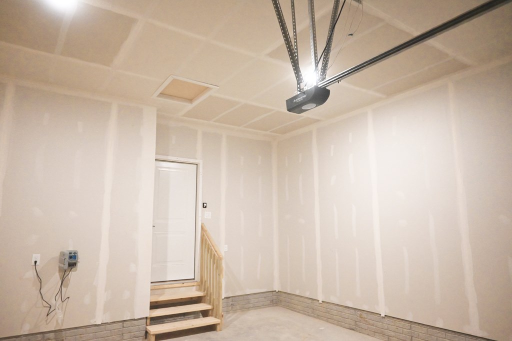 A room with a staircase and a light hanging from the ceiling.