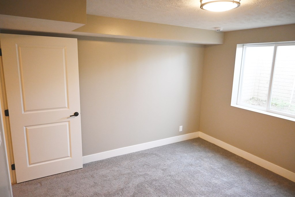A room with a white door and a window with blinds.
