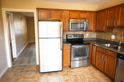 A kitchen with a white refrigerator, stainless steel oven, and microwave.