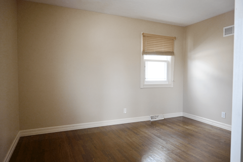 A room with a window and wooden floors.