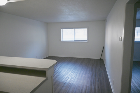 A room with a window and wooden floor.