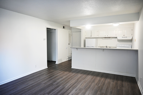 A kitchen area with white cabinets and a refrigerator.