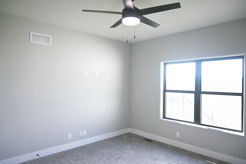 A room with a ceiling fan and a window.