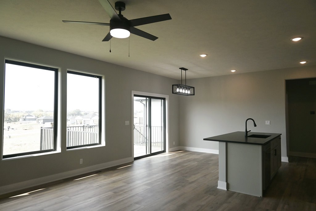 A room with a ceiling fan and a kitchen island.
