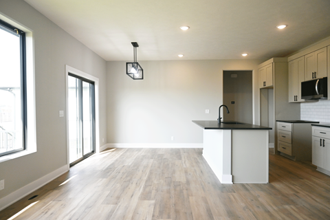 A kitchen with a black countertop and white cabinets.