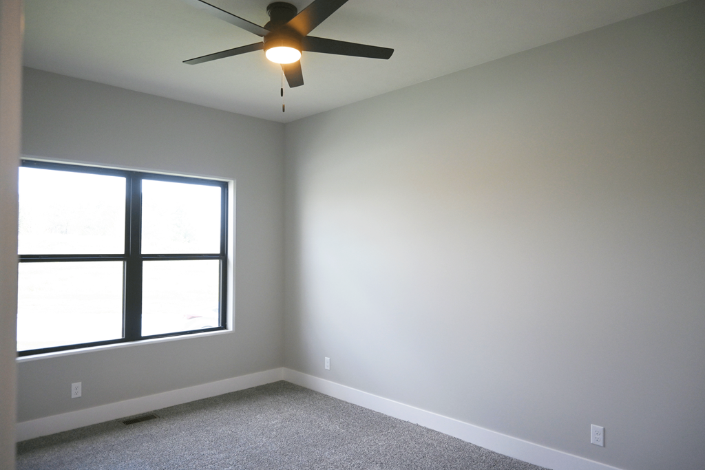 A room with a ceiling fan and a window.