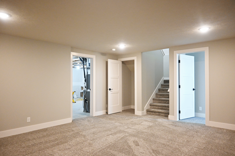 A spacious room with carpeted floor and white walls.