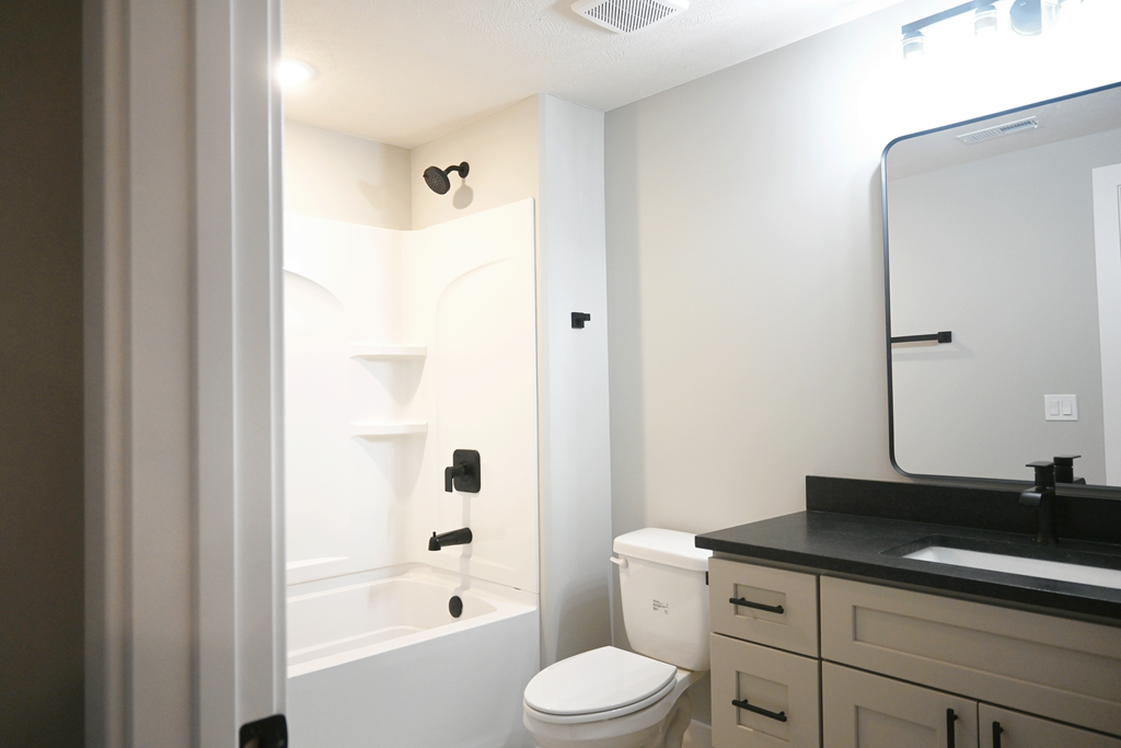 A bathroom with a toilet, sink, and bathtub.