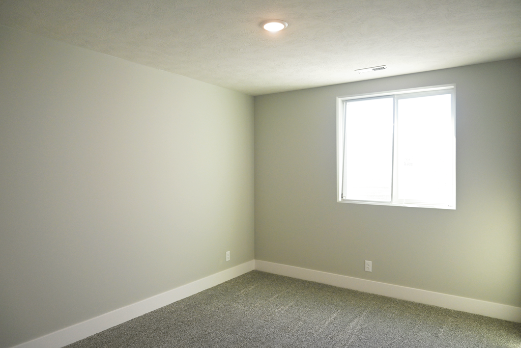 A room with a window and carpeted floor.