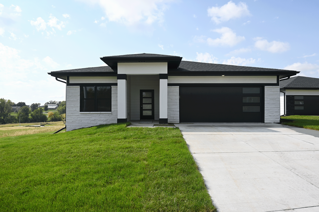 A modern house with a black roof and a white exterior.