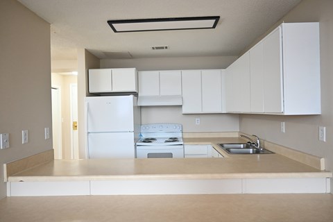 A kitchen with white appliances and cabinets.
