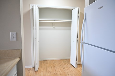 A white refrigerator is in a kitchen with a white door.
