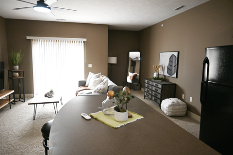A dining room with a table set for two and a ceiling fan.