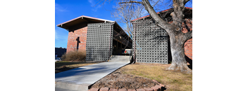 Building exterior of Unit 2: 1 Bed, 1 Bath at Slips at Blackstone with a brick facade, glass block walls, and sidewalk entry.