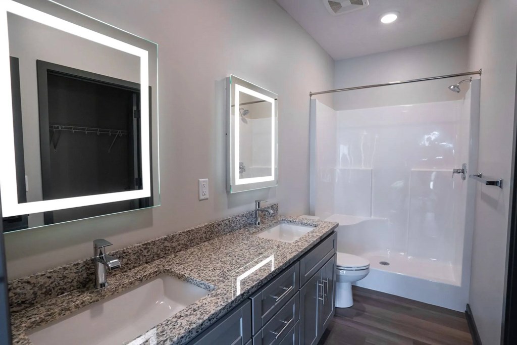 A bathroom with a sink, mirror, and bathtub.