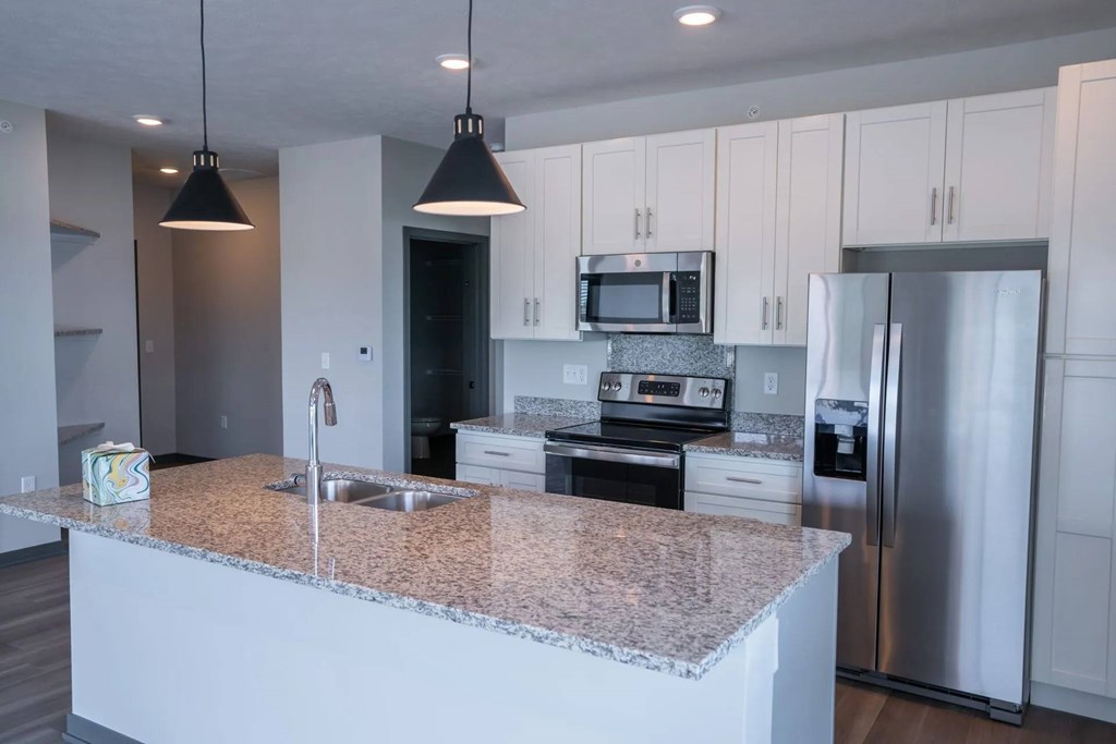 A kitchen with granite countertops and stainless steel appliances.