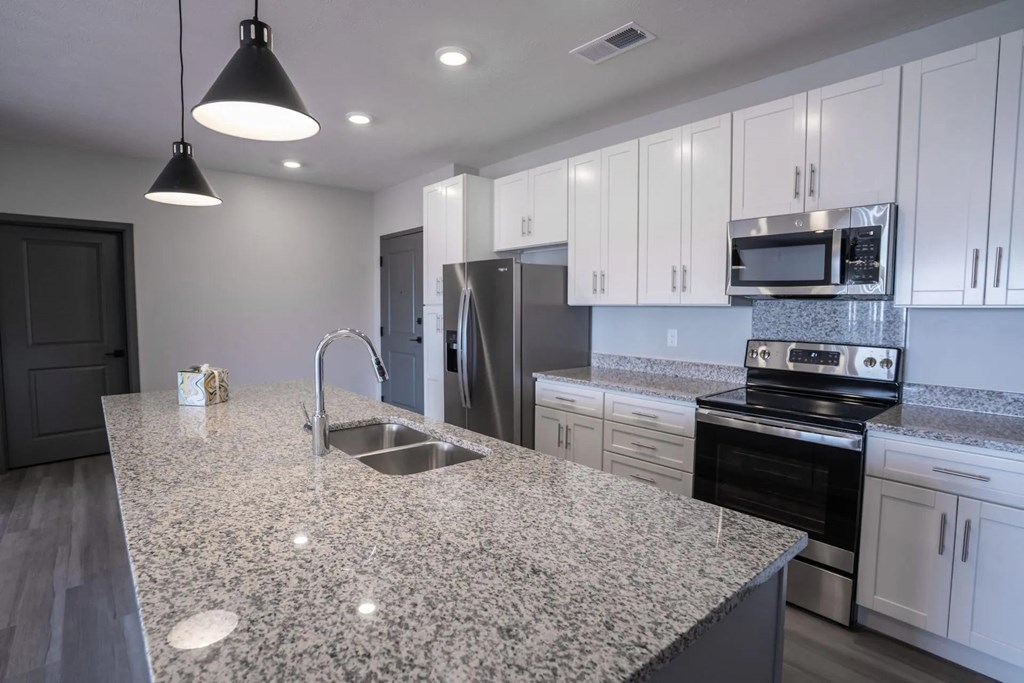 A kitchen with granite countertops and stainless steel appliances.